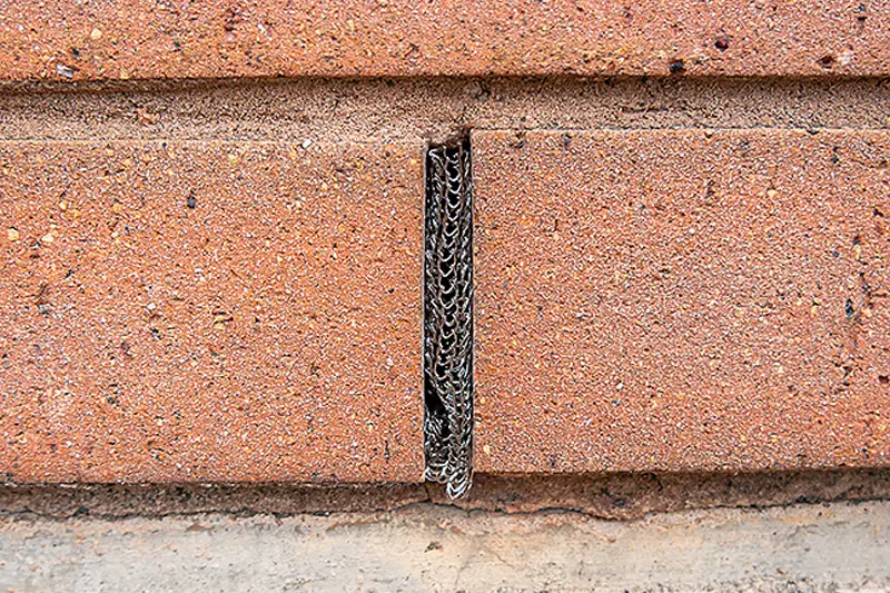 Weep hole gap space in-between the bricks of a brick wall